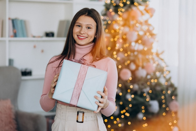 Jonge kerstmis van de vrouwenholding huidig door kerstmisboom