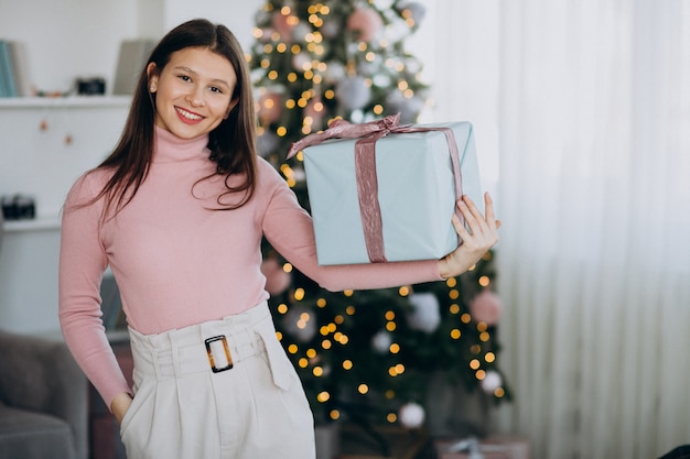 Jonge Kerstmis van de vrouwenholding huidig door Kerstmisboom