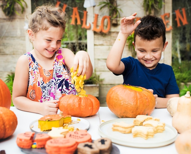 Jonge kinderen snijden halloween jack-o'-lantaarns