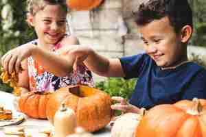 Gratis foto jonge kinderen snijwerk halloween jack-o-lanterns