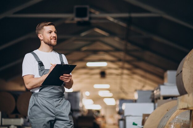 Jonge knappe man aan het werk in een fabriek