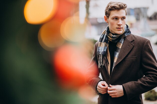 Jonge knappe man in een jas buiten de straat