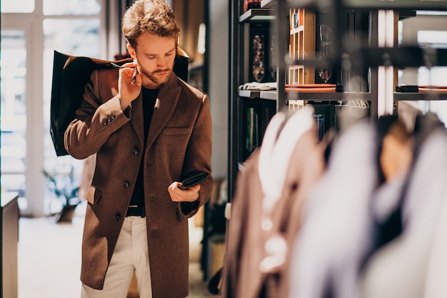 Jonge knappe man kiezen doek bij winkel