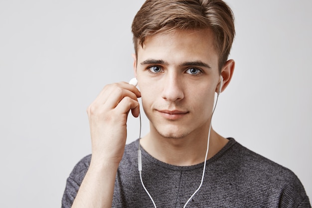 Jonge knappe man luistert muziek met koptelefoon