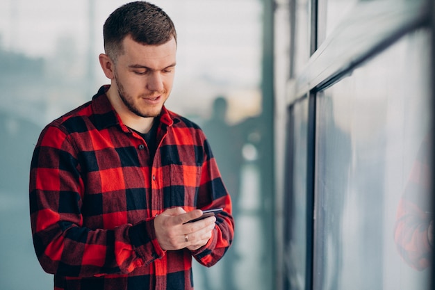 Jonge knappe man met behulp van de telefoon