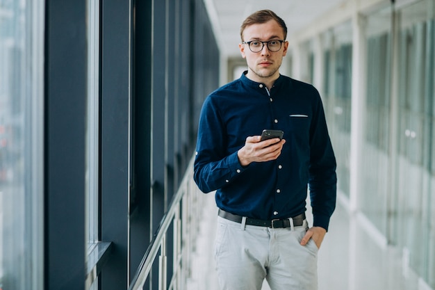 Jonge knappe man praten aan de telefoon op kantoor