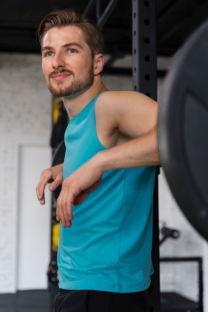 Jonge knappe man traint in de sportschool voor bodybuilding