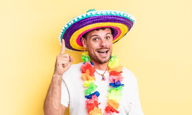 Jonge knappe man voelt zich een gelukkig en opgewonden genie nadat hij een idee heeft gerealiseerd. mexicaans feestconcept