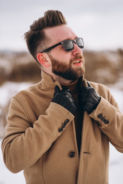 Jonge knappe mens die zich in de winterpark bevindt, portret