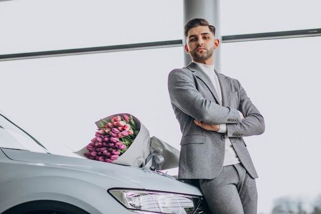 Jonge knappe zakenman leveren boeket van mooie bloemen