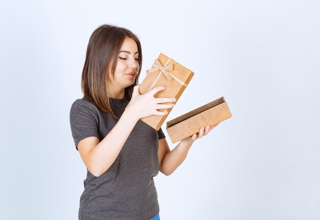 jonge lachende vrouw die een geschenkdoos opent.