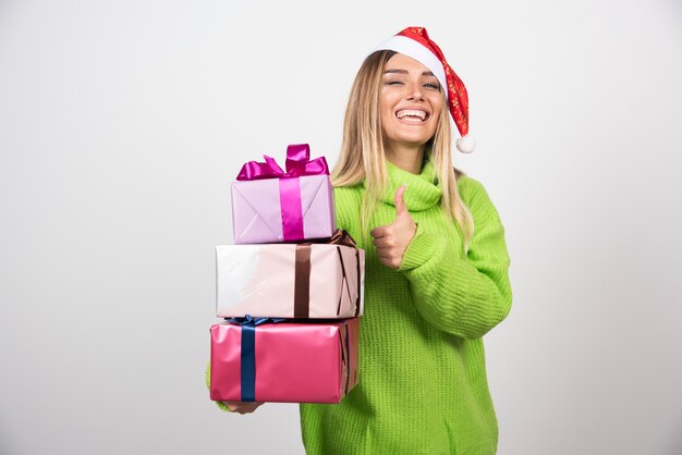 Jonge lachende vrouw in handen feestelijke kerstcadeautjes te houden