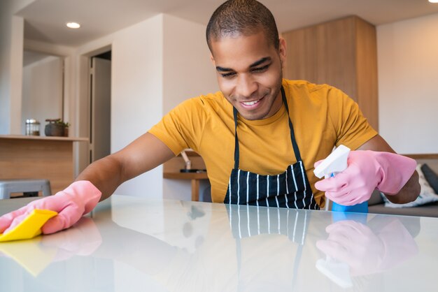 Jonge Latijns-man thuis schoonmaken.