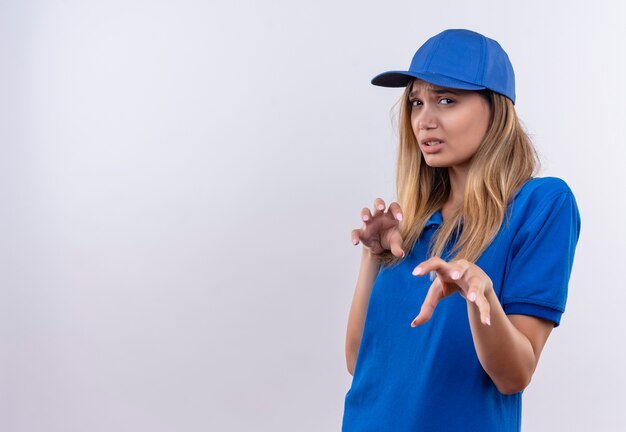 jonge leveringsvrouw die blauw uniform en pet draagt die tijgergebaar toont