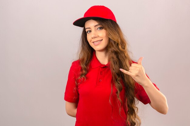 Jonge leveringsvrouw die rood poloshirt en GLB draagt die me gebaar maken die over geïsoleerde witte achtergrond vertrouwen kijken