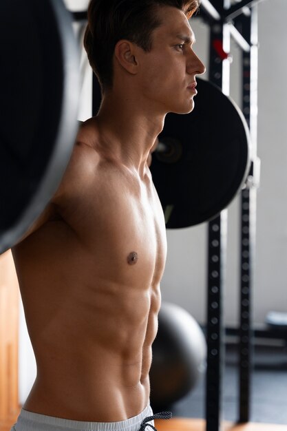 Jonge man aan het trainen in de sportschool voor bodybuilding