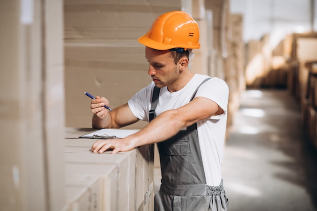 Jonge man aan het werk in een magazijn met dozen