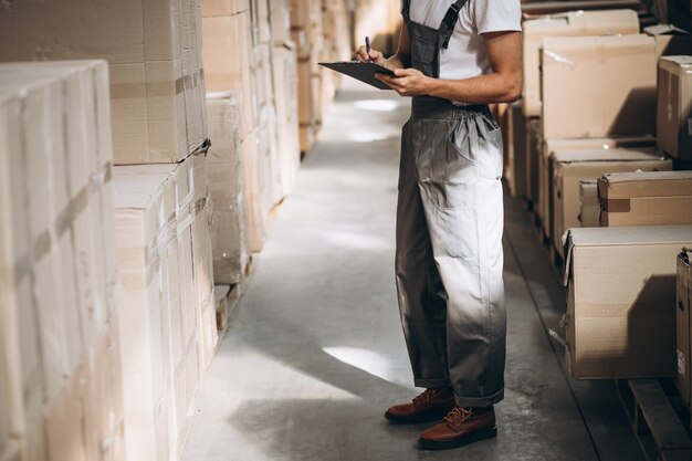 Jonge man aan het werk in een magazijn met dozen