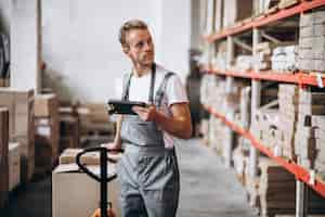 Gratis foto jonge man aan het werk in een magazijn met dozen