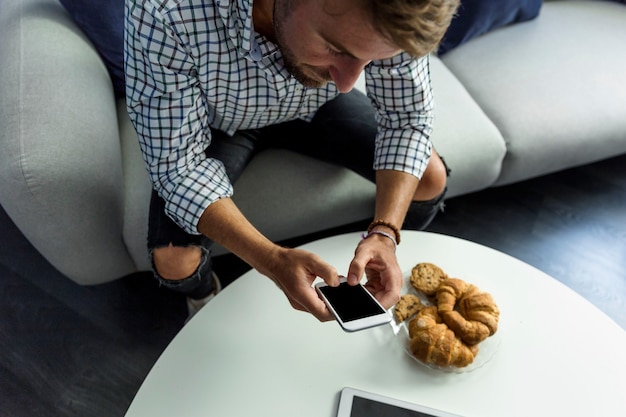 Jonge man aan het werk met smartphone