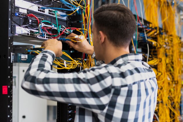 Jonge man aan het werk op een ethernet-schakelaar