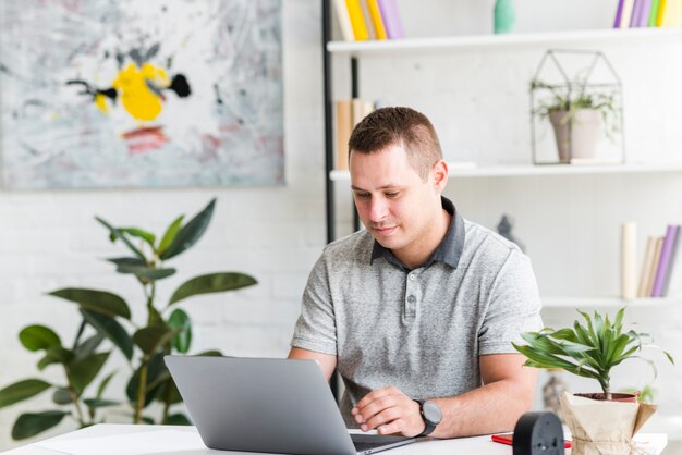 Jonge man aan het werk op laptop thuis