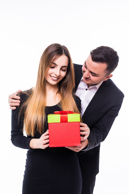 Jonge man aanwezig cadeau aan zijn vriendin vrouw in rode doos op wit