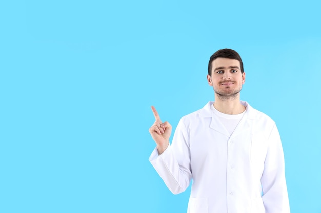 Jonge man arts op blauwe achtergrond, gezondheidszorg en geneeskunde