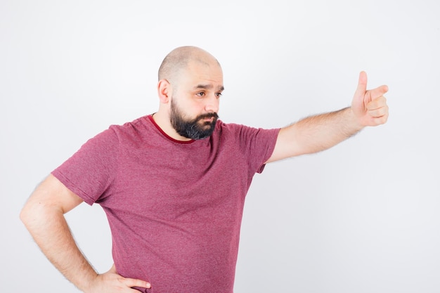 Jonge man belt iemand met de hand in roze t-shirt vooraanzicht.