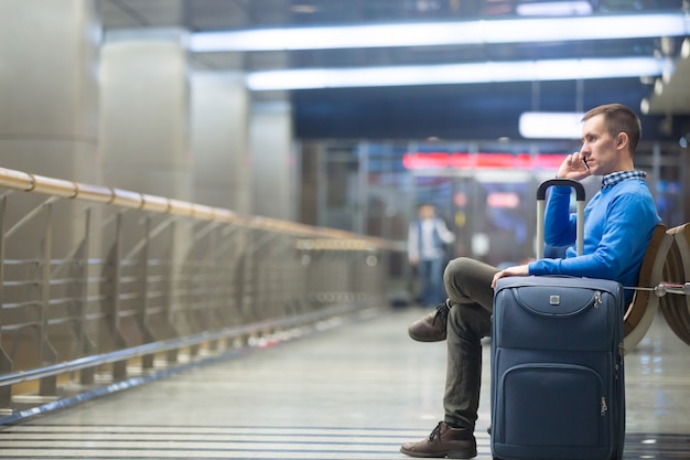 Gratis foto jonge man belt op luchthaven