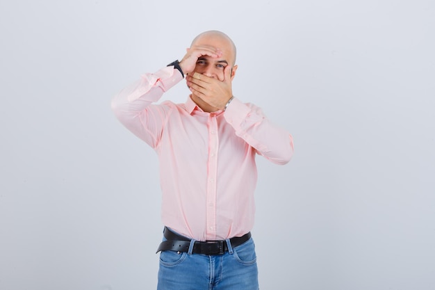 Jonge man die de mond bedekt met de hand