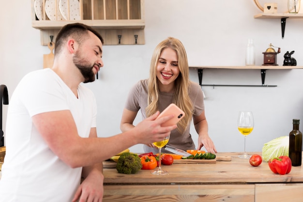 Gratis foto jonge man die de telefoon toont aan vrouw