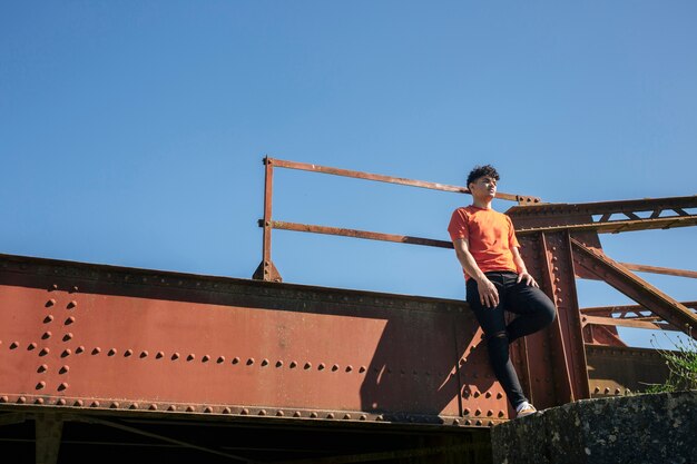 Jonge man die op metalen brug