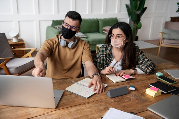 Jonge man die zijn vriend iets op zijn laptop laat zien tijdens studiesessie