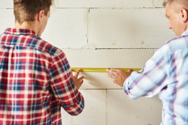 Jonge man en oude meten de muur