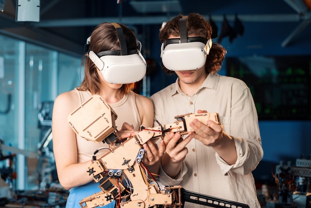 Gratis foto jonge man en vrouw in beschermende bril doen experimenten in robotica in een laboratorium robot