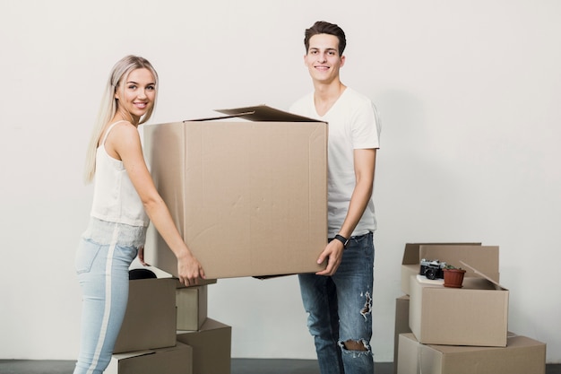 Gratis foto jonge man en vrouw met kartonnen doos