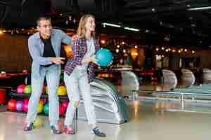 Gratis foto jonge man en vrouw plezier in een bowlingclub