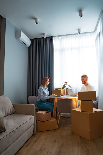 Jonge man en vrouw zitten aan tafel, werken op laptop in co-working office