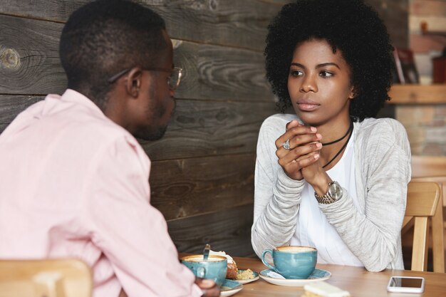 Jonge man en vrouw zitten in café