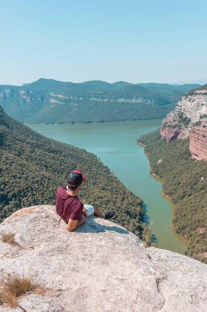 Jonge man geniet van het betoverende landschap van de Morro de la Abeja in Tavertet, Catalonië, Spanje