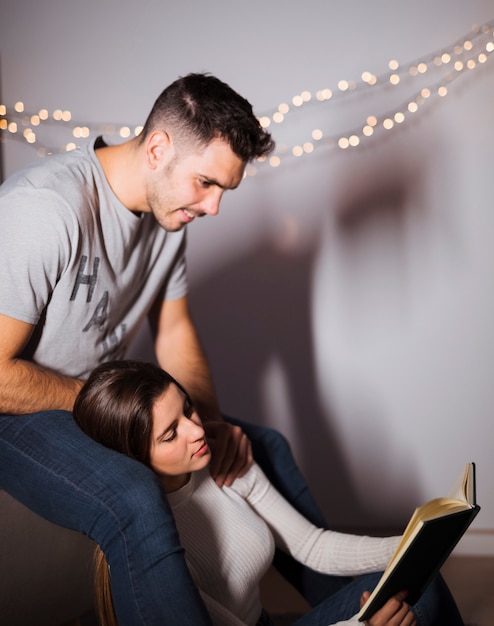 Jonge man in de buurt van vrouw leesboek