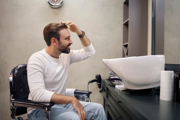 Jonge man in de kapperszaak nadat hij is geknipt