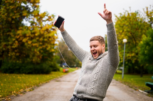 Gratis foto jonge man in grijze blouse in het park