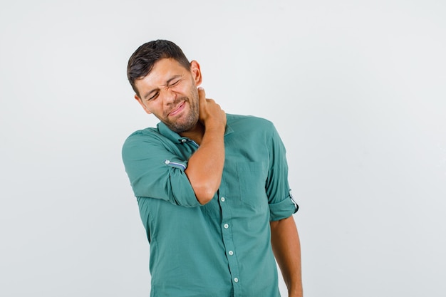 Jonge man in shirt die lijden aan pijn in de nek