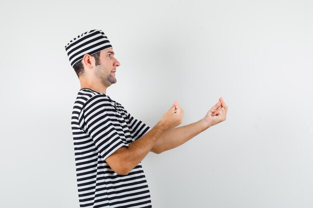 Jonge man in t-shirt, hoed doet Italiaans gebaar, ontevreden over domme vraag.