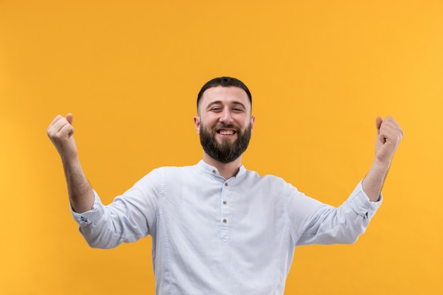 Jonge man in wit overhemd met baard met opgeheven handen