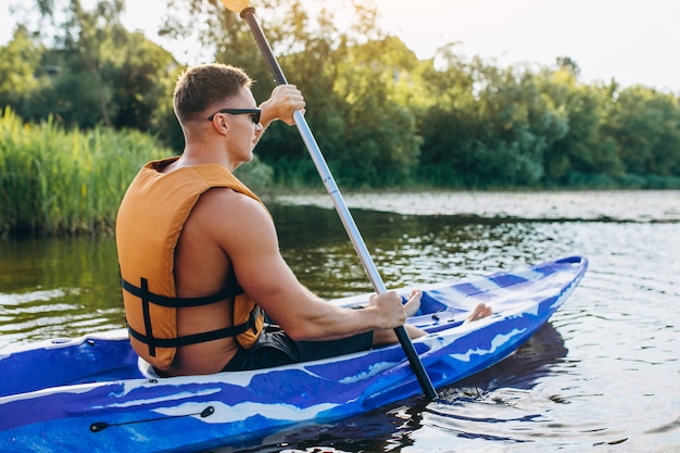 Gratis foto jonge man kajakken op de rivier