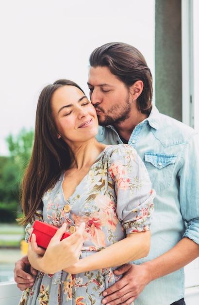 Gratis foto jonge man kussende vrouw met heden op wang