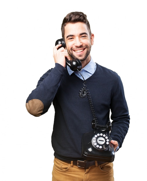 Gratis foto jonge man lachen en praten aan de telefoon